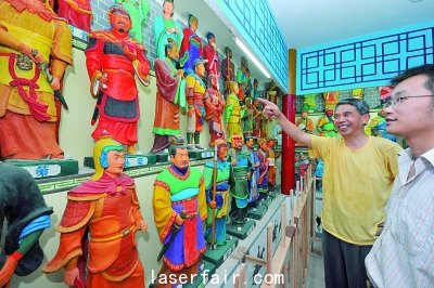 襄陽一老人在自辦的“三國人物泥塑館”為參觀者介紹自己的泥塑作品。