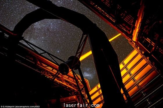 智利歐洲南方天文臺(tái)帕拉納爾天文臺(tái)操作的這個(gè)新PARLA激光器。從圖上可以看到，7瓦特激光器發(fā)出的橙黃色光束從甚大望遠(yuǎn)鏡的望遠(yuǎn)鏡4的穹隆結(jié)構(gòu)射向高空。在背景圖上還能看到大麥哲倫云