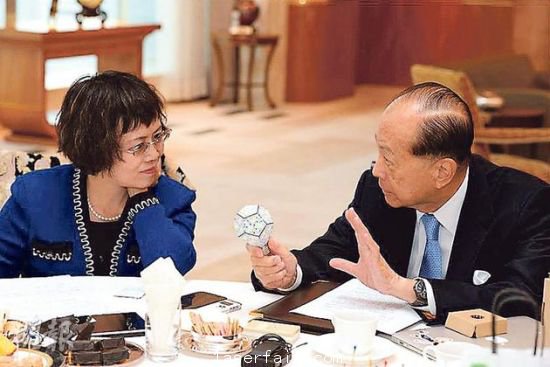 李嘉誠（右）在接受媒體訪問時指出，長實集團(tuán)以香港為基地，常常積極在港尋找投資機(jī)會，但是政府很多政策，需時消化。圖為他向財新傳媒總編輯胡舒立介紹他本周的“最愛”納米LED燈泡。圖片來源：香港明報